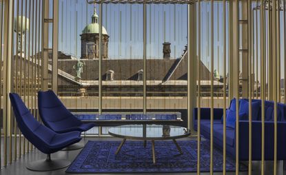 W Hotel lobby with brass cage structure, blue sofa and chairs and blue rug