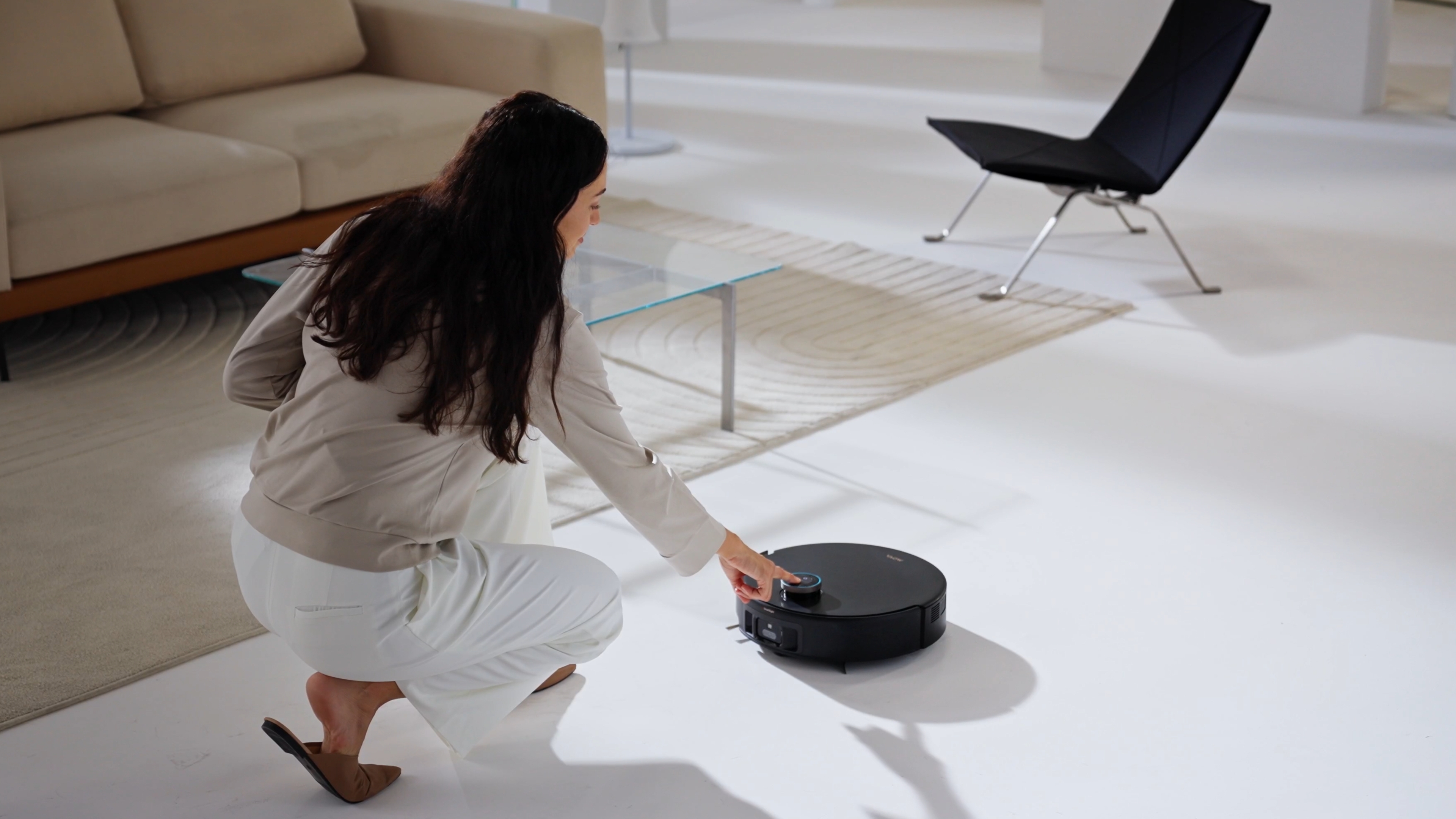 A woman touching her MOVA robot vacuum.