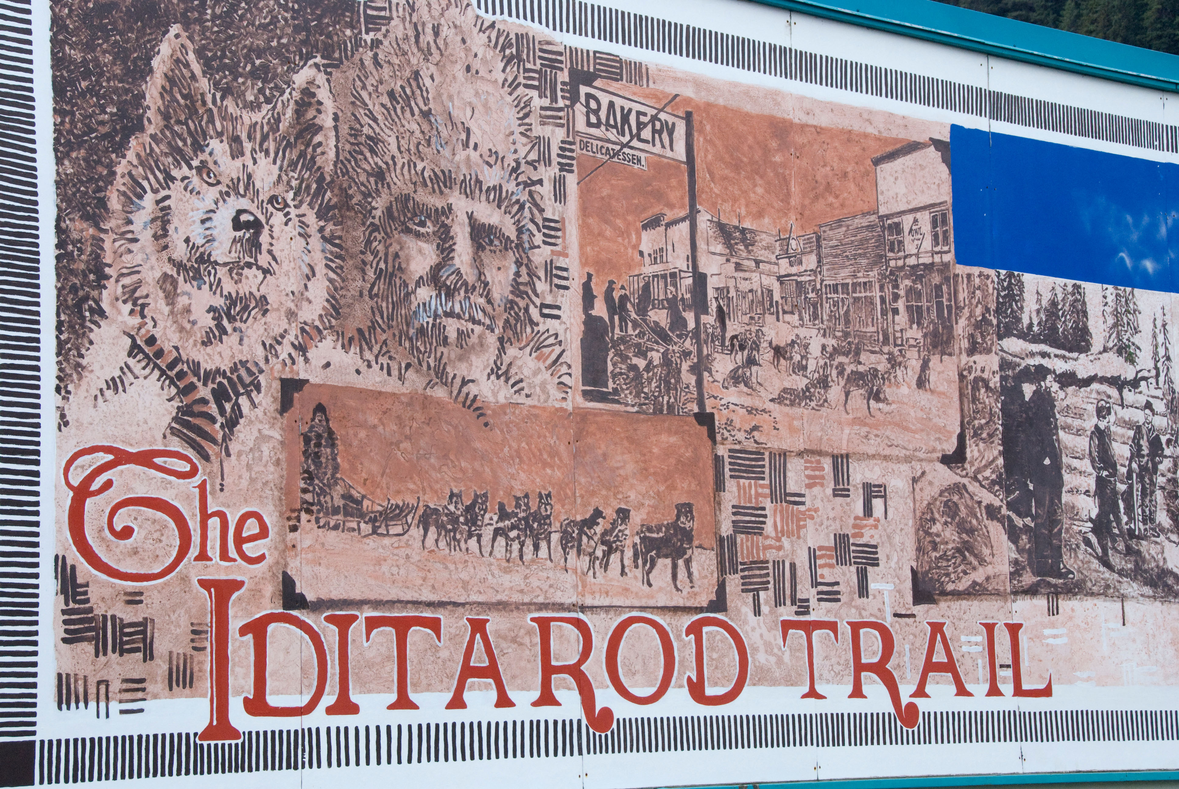 A painted mural shows historic scenes from the Iditarod Trail, including sled dogs, mushers and frontier life.