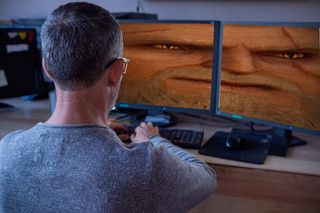 infamous stretched "biggeralt" photoshopped into stock image of man working across two monitors