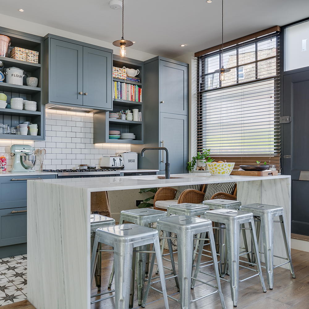 kitchen with white counter white tables blue cabinets shelf on wall