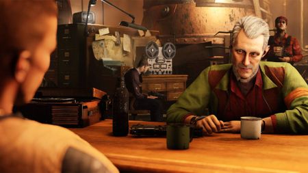 Wolfenstein 2: The New Colossus screenshot shows two people sat at a table.