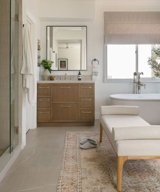 Beige soft bathroom with freestanding tub and ottoman