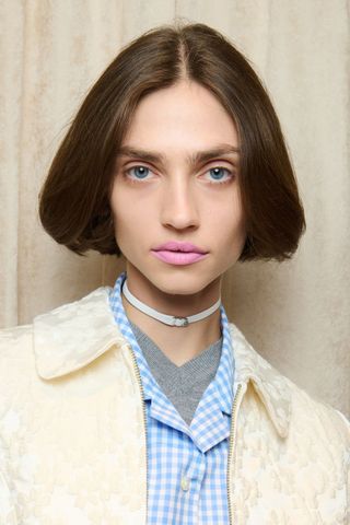 Model backstage at Sandy Liang wearing soft pink, a key Spring/Summer 2025 Fashion Month beauty look