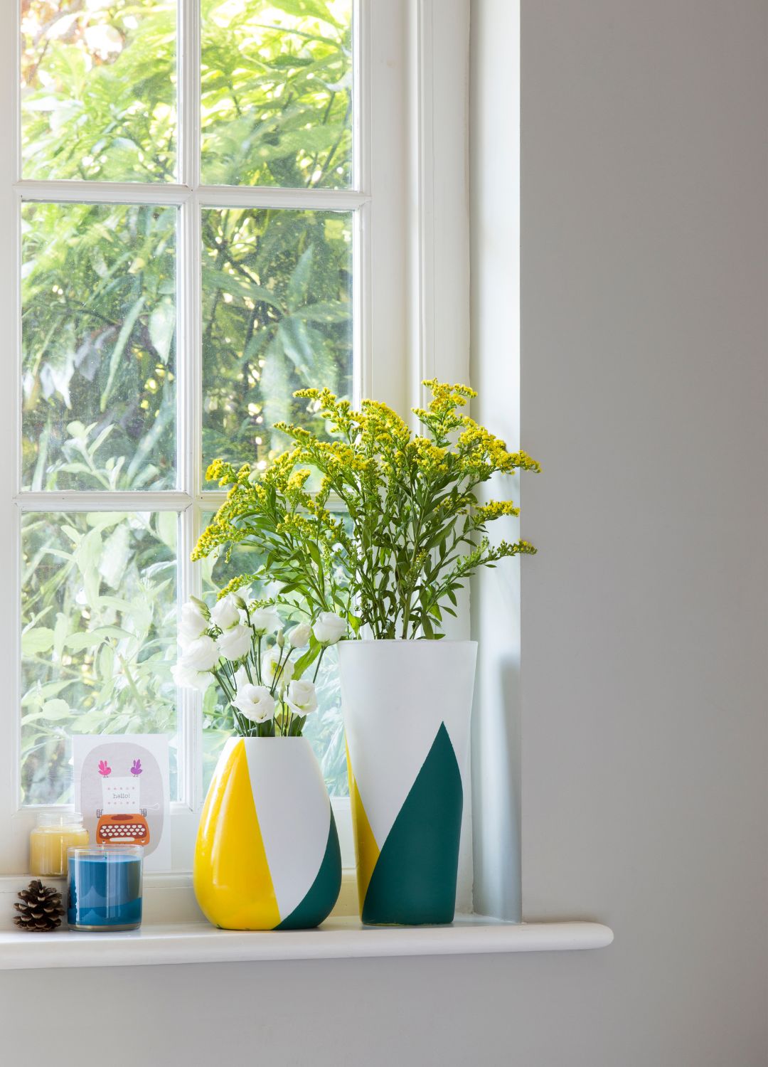 windowsill with vases and candles on it