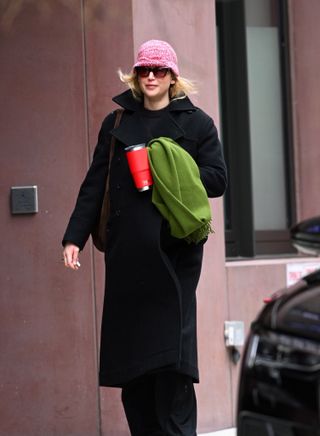 Jennifer Lawrence walks in Manhattan wearing a Dior coat with a Liffner bag