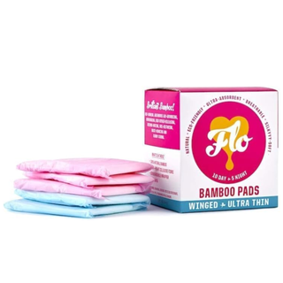 box of flo products next to pink and blue sanitary pads folded in a stack