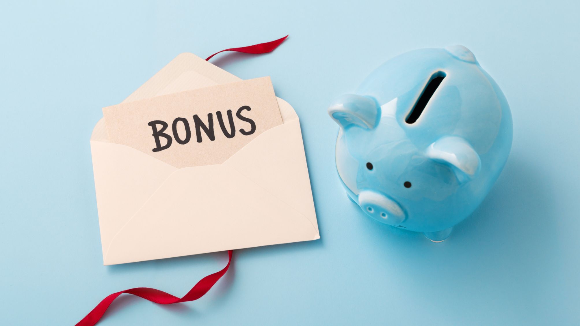 A blue piggy bank next to a note in an envelope that says Bonus 