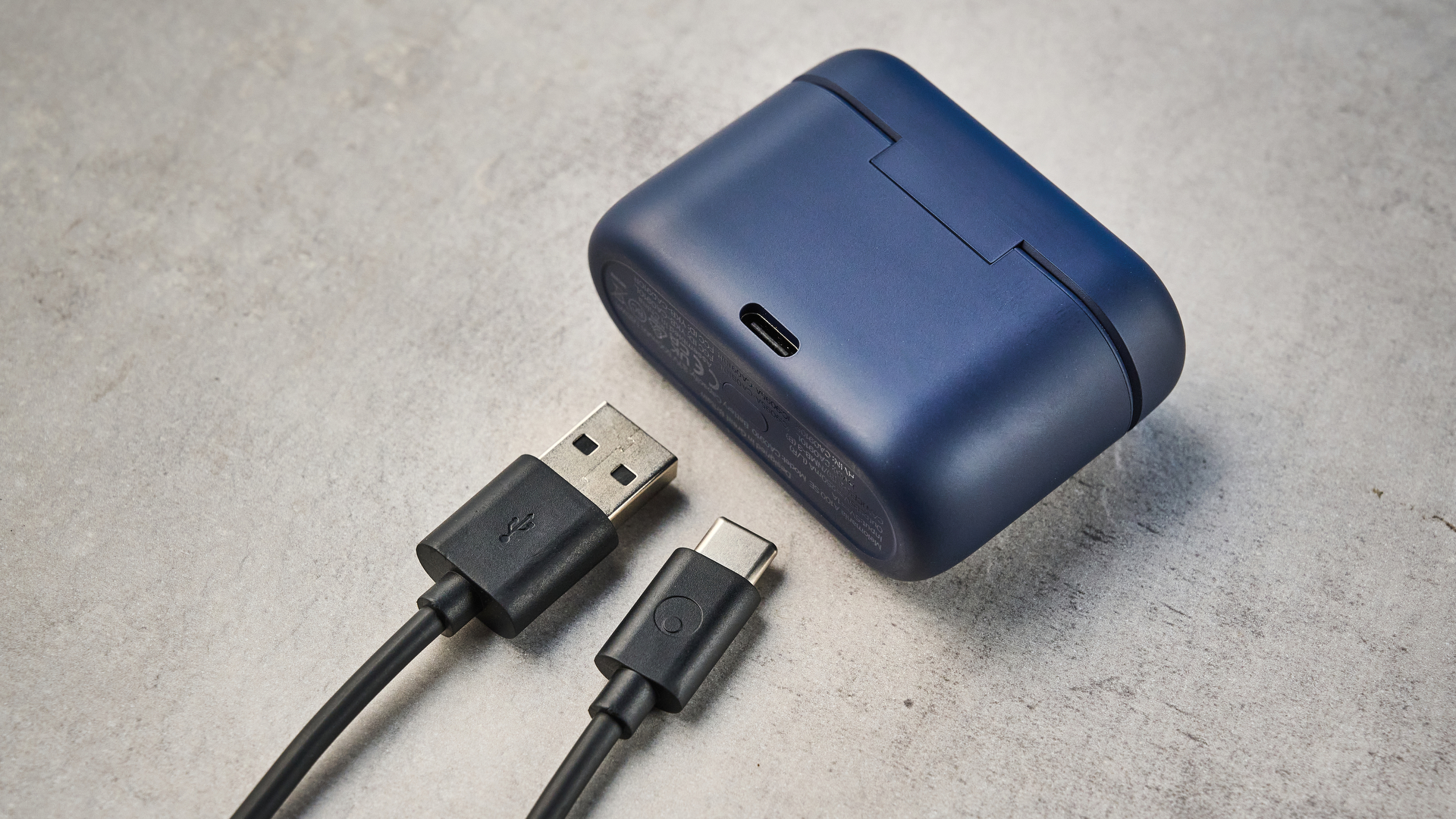 the cambridge audio a100 se earbuds on a blue tom's guide background with a stone-coloured table underneath