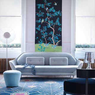 white room with grey sofa in front of floral wall art