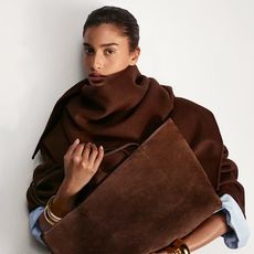 model holding a chocolate brown suede handbag