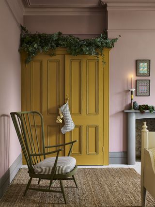 Pink bedroom with yellow wardrobe and Christmas stocking by Annie Sloan