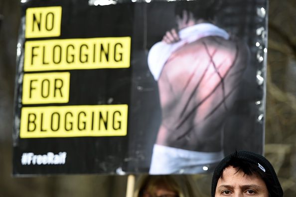 A protester carries a sign at a rally calling for the release of Saudi blogger Raif Badawi.