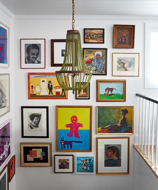 landing with gallery wall of colorful artwork and green pendant