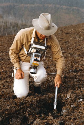 During a December 1969 simulation, astronaut Jim Lovell, commander of the upcoming Apollo 13 lunar landing mission, practices with a scoop from the Apollo Lunar Hand Tools. The lunar surface traverse exercise took place at the Kapoho, Hawaii training site.