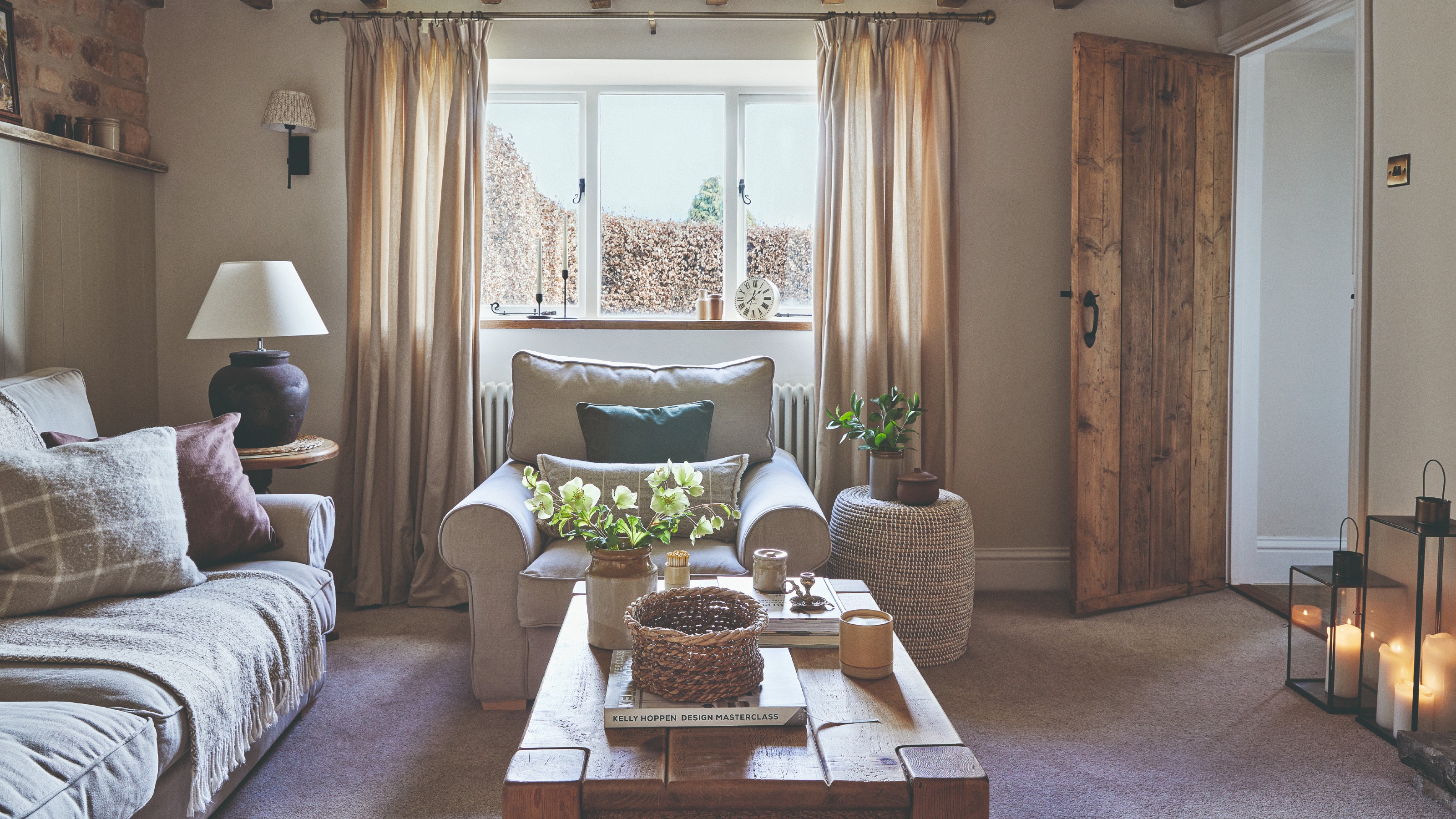 A small rustic living room with a beige sofa, an armchair and a wooden coffee table