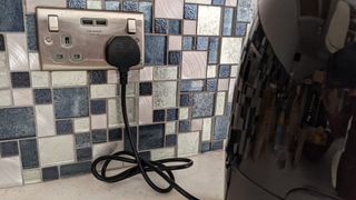 An air fryer cable plugged in and tied with a cable tie