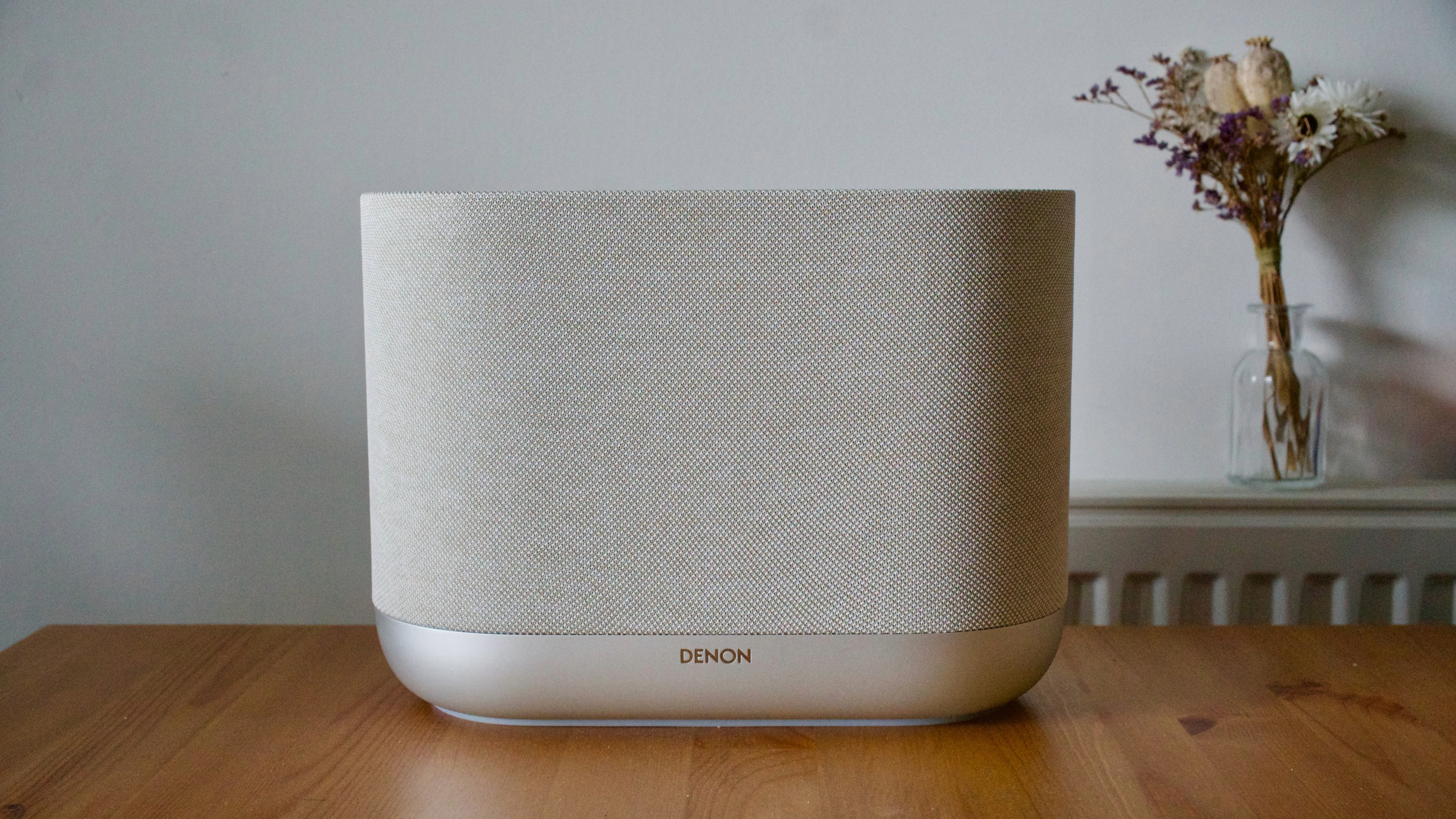 Denon Home 400 home speaker on a wooden surface