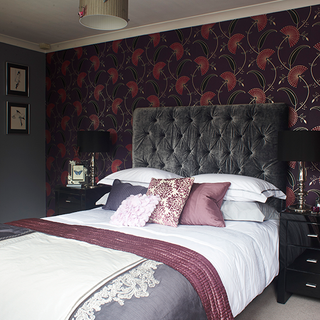 bedroom with plum and pink wallpaper and grey bed