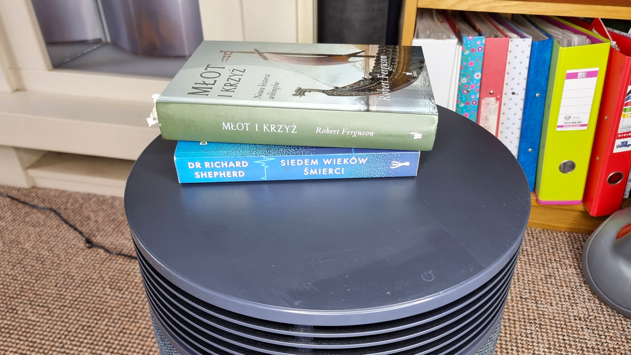 a close-up picture of a stack of books sitting on top of the Blueair Blue Signature air purifier
