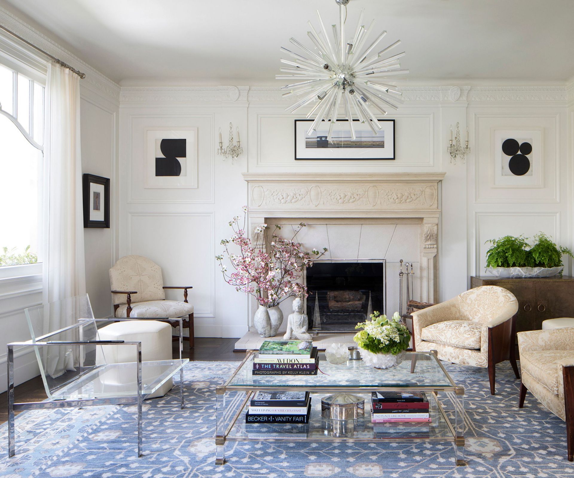 living room with transparent chair and blue area rug and fireplace