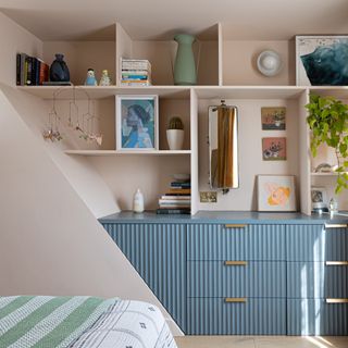 A pink-painted bedroom with a gallery wall display