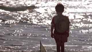 Truman as a little kid looks out into the water.