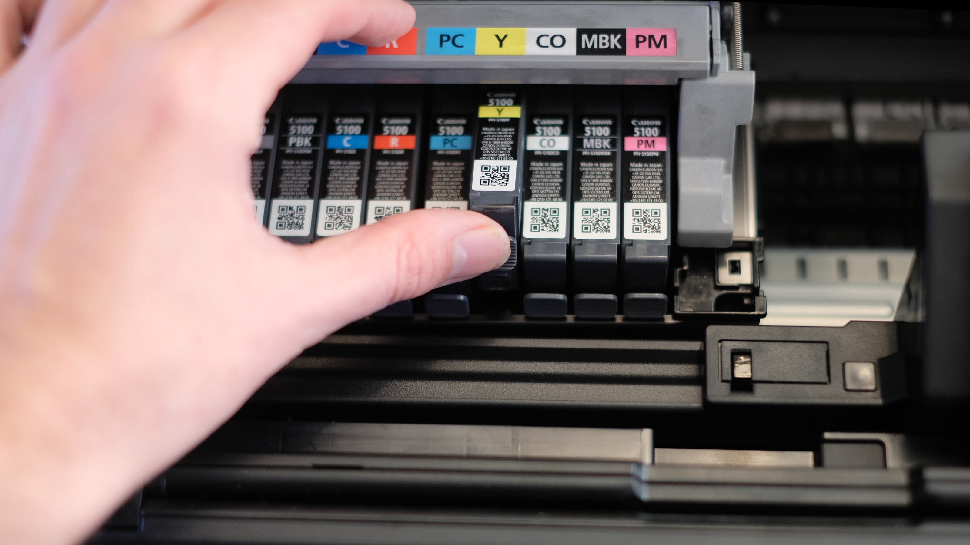 A photograph of the Canon imagePROGRAF PRO-310 printer open with an ink tank being changed.