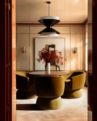 A dining room with light green/yellow dining chars, and a black pendant light installed above