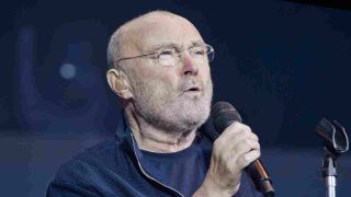 Phil Collins performing onstage in 2022