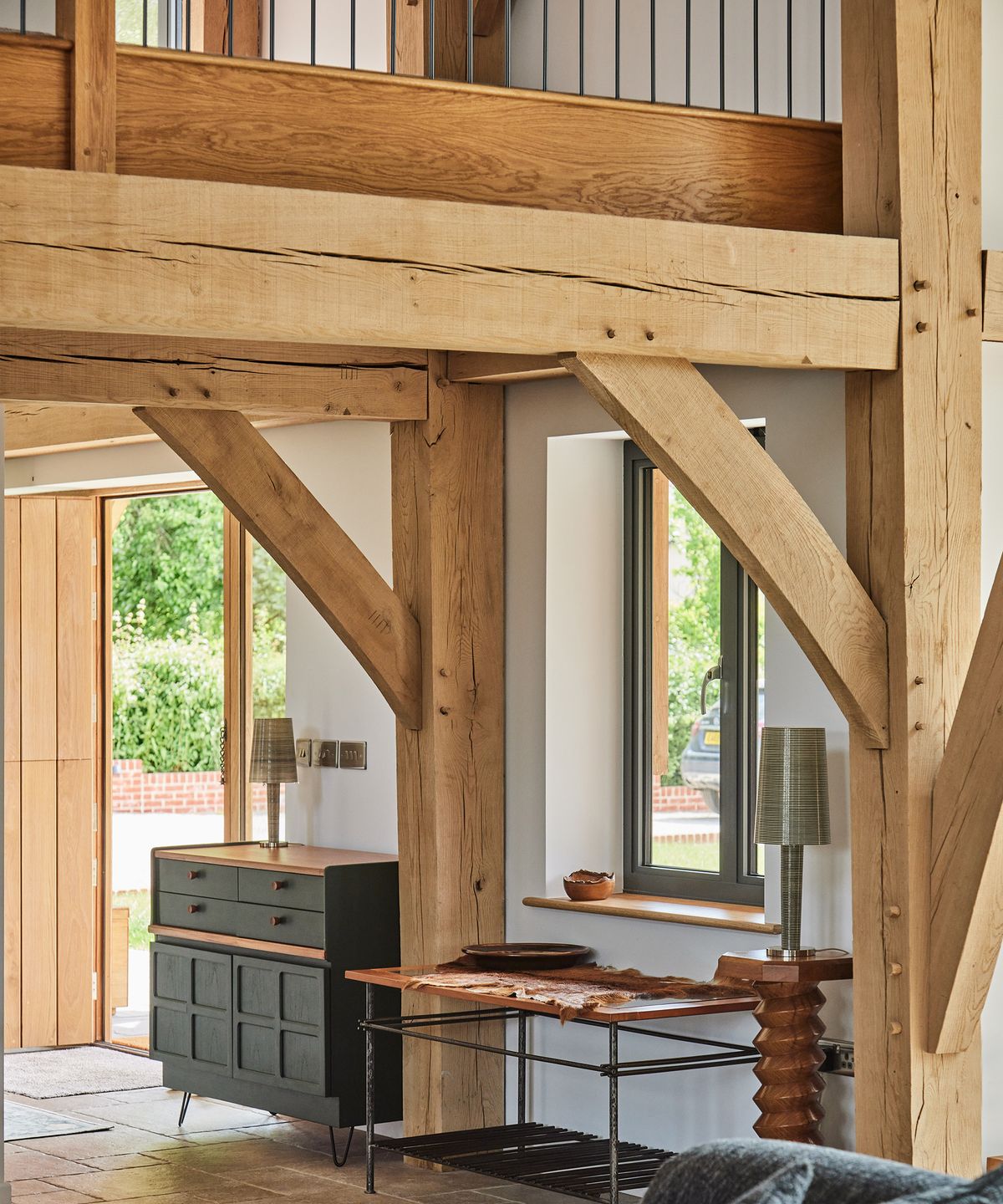 A hallway in an oak-frame home with a glimpse of the landing above
