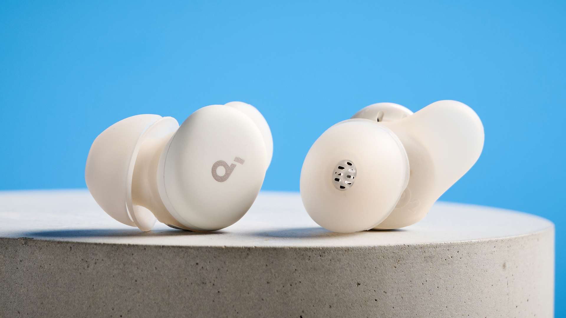 The Soundcore Sleep A30 earbuds on a stone plinth against a blue background