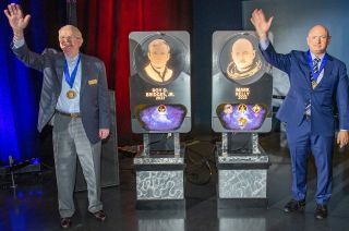 Roy Bridges (at left) and Senator Mark Kelly wave and pose with their plaques that will hang in the Astronaut Hall of Fame, part of the Heroes & Legends attraction at Kennedy Space Center Visitor Complex, on Saturday, May 6, 2023.