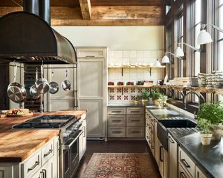 kitchen with off white cabinets, range hood, patterned tile splashback and patterned rug