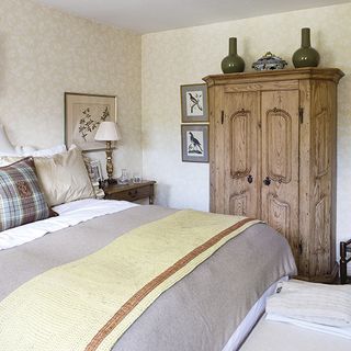 bedroom with floral wallpaper and wooden cupboard