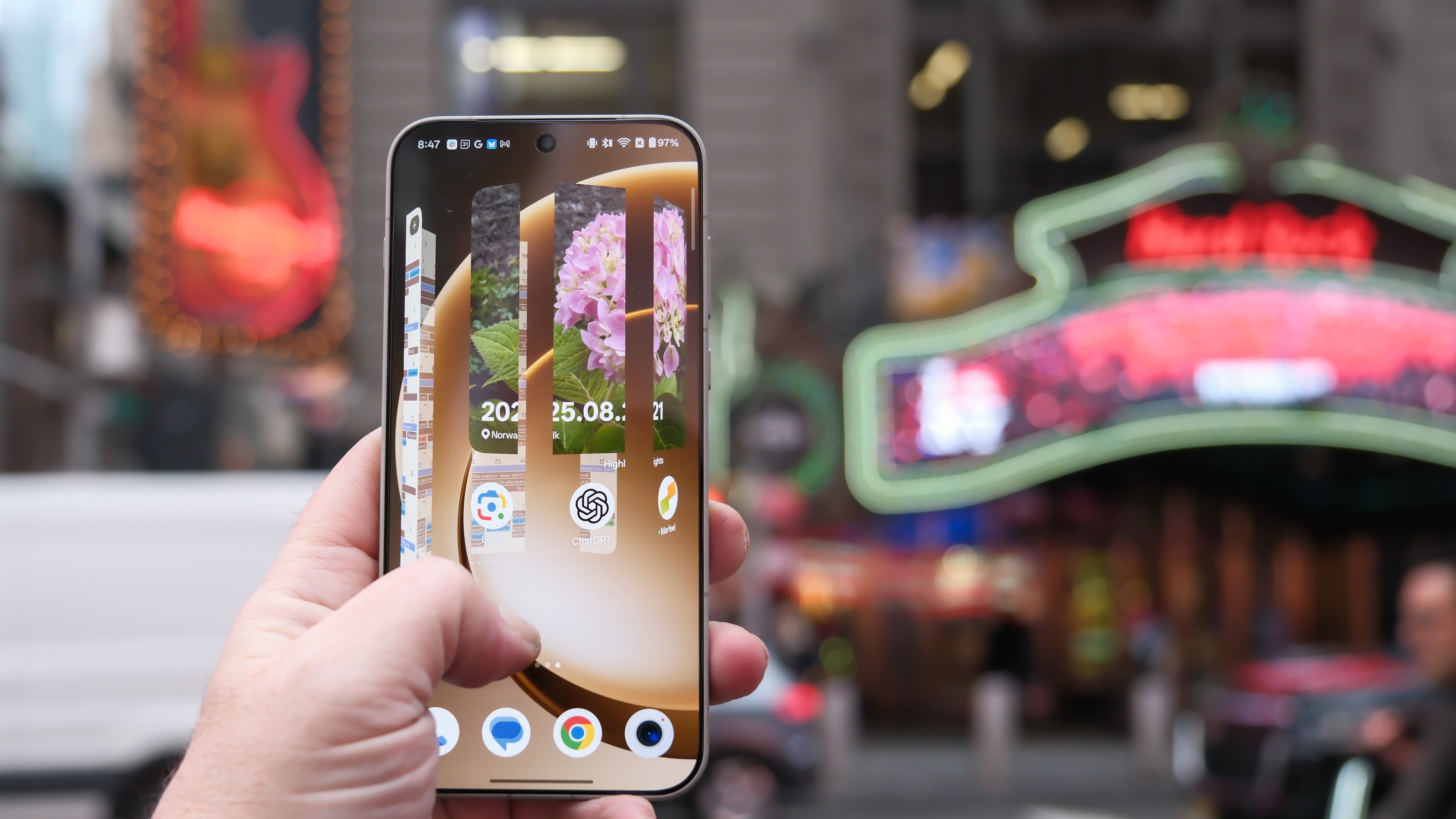 OnePlus 15 in Times Square New York City on the busy street showing the cameras and sides of the phone in addition to home screen panels and Settings menus