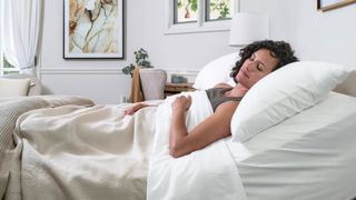 Woman sleeping on her Saatva Adjustable Bed with the top of the bed at a slight incline