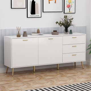 A white side cabinet with gold handles and three drawers