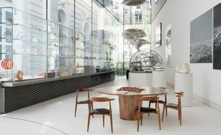 Glass showcasing cabinet and wooden table and chairs in front