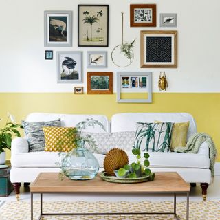 Bright living room with half painted yellow wall and a organic picture wall arrangement