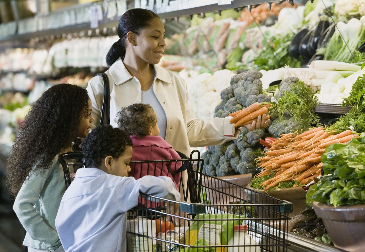 Family grocery shops in the produce aisle.