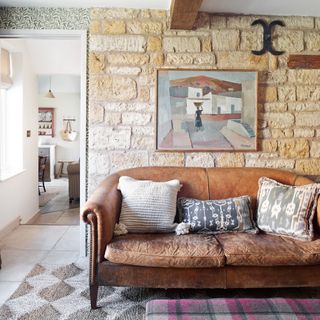 aged leather sofa in a cottage with an exposed honey brick wall