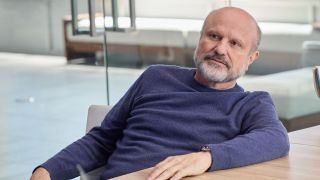 Enrico Colantoni seated at a conference table in Suits LA