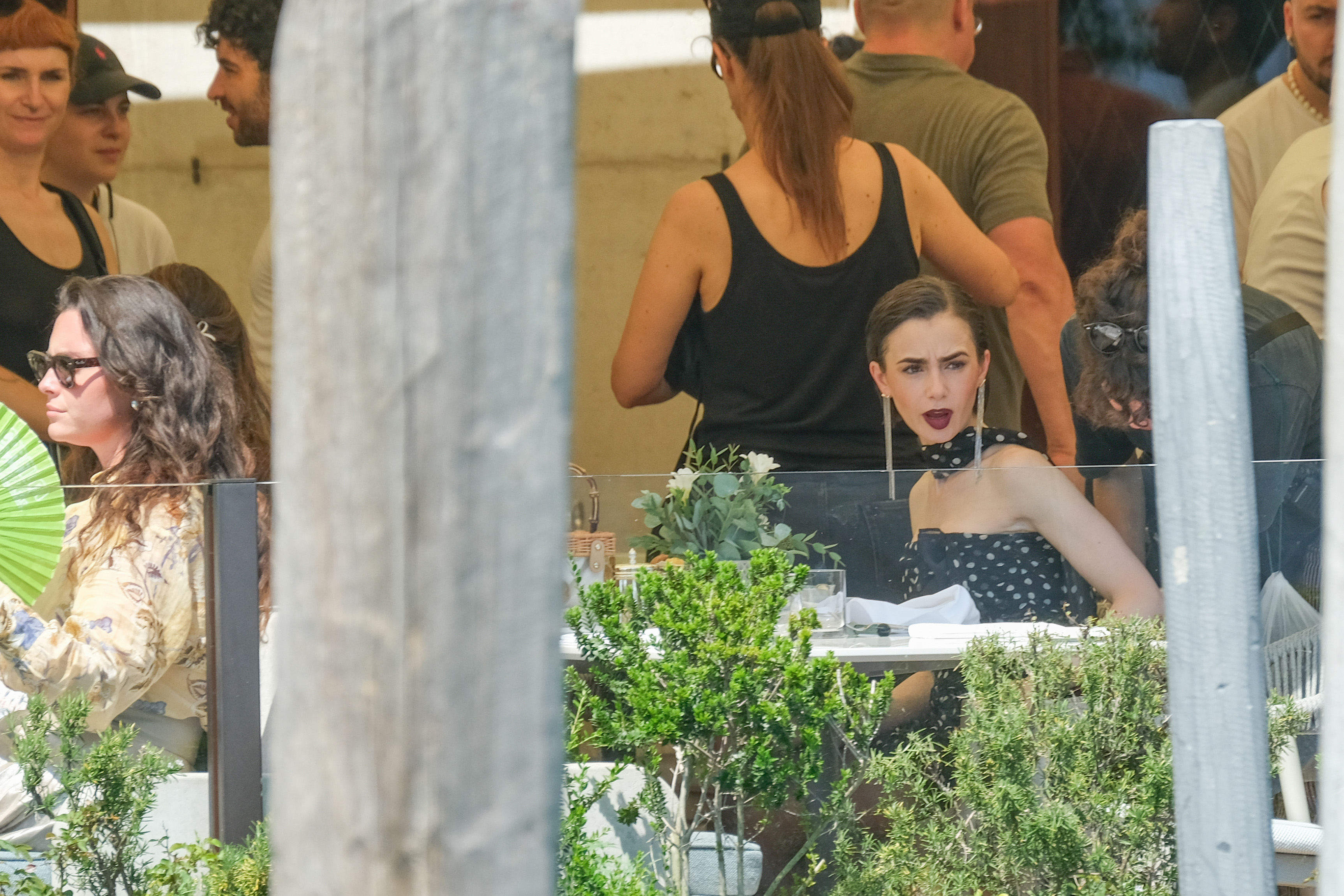 Lily Collins filming Emily in Paris wearing a black and white polka-dot gown