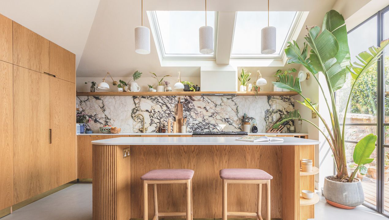 wooden kitchen with marble splashbacks and potted palm 