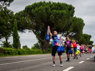 Soigneurs hand out musettes to riders