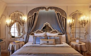Opulent bed in Disneyland Paris Hotel room, with drapes, mirrors and chandeliers