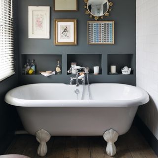 grey bathroom with alcoves for toiletries and a feature wall above a bath