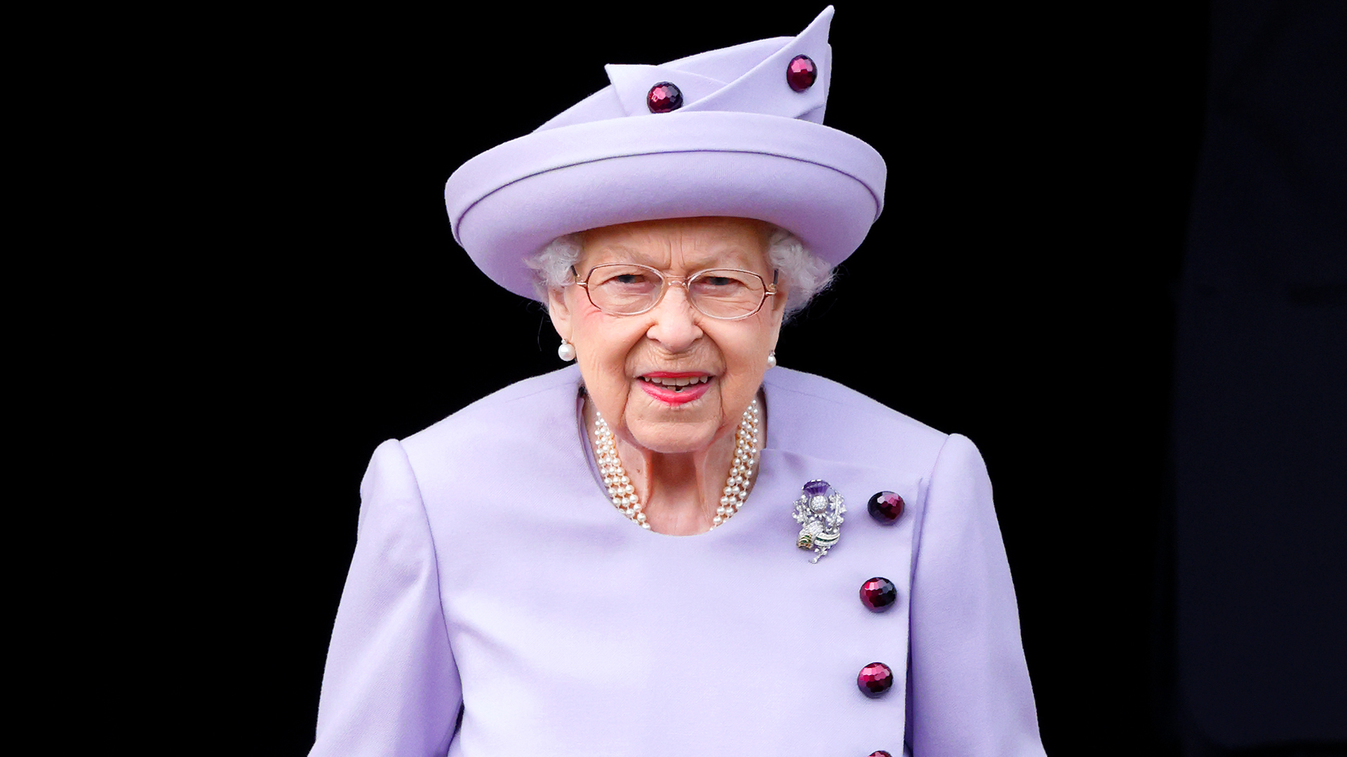 Queen Elizabeth wears a lilac dress and matching hat