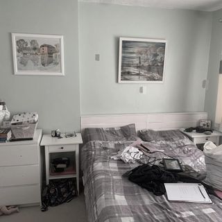 A busy bedroom with a double bed and two white side tables